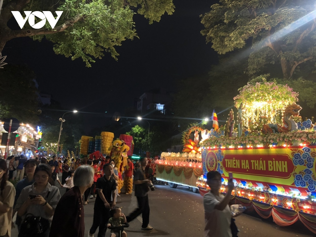 Many people attend the procession of flower vehicles and Buddha relics through Ly Thuong Kiet, Ba Trieu, and Tran Hung Dao streets.