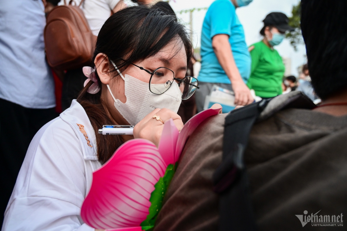 Lan Anh, a local resident, writes letters praying for peace and happiness to herself, relatives, and friends before dropping the lotus-shaped lantern.