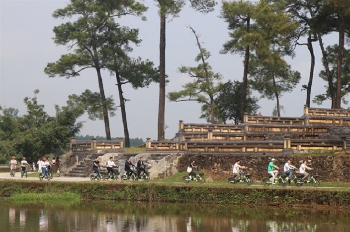Tourists experience a cycling tour at the Tomb of King Gia Long in the central coastal province of Thua Thien Hue.— VNA/VNS Photo Tuong Vi