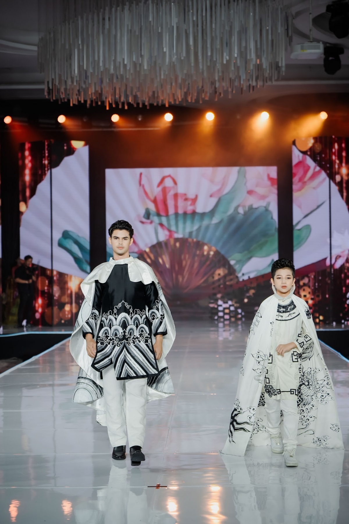 Kim Thitisan Goodburn, the winner of Mister International Thailand 2023 (L), moves down the catwalk whilst wearing an Ao Dai featuring special patterns.