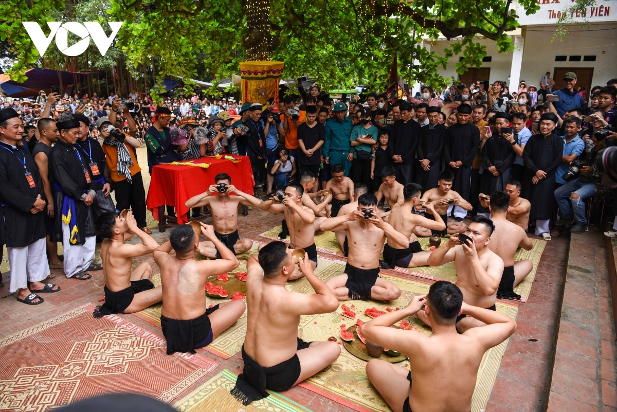 Wrestlers of competing teams perform a traditional ritual in front of the temple, in which they drink wine believed to help boost their strength and spirit.