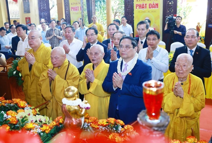 Prime Minister Pham Minh Chinh (second from the right, first row) and Vietnam Buddhist Sangha's dignitaries perform the traditional rituals of bathing the Buddha.