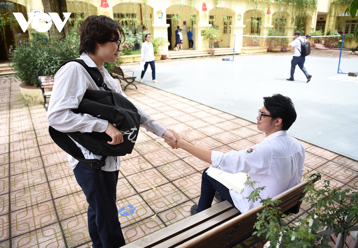 Two students shake hands with each other, expecting to get high results and enter their desired university.