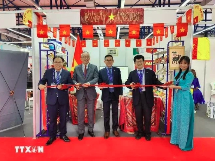 Ambassador Tran Quoc Khanh (middle) and trade counselor Hoang Duc Nhuan (left) cut the ribbon to launch the Vietnam pavilion at the fair.