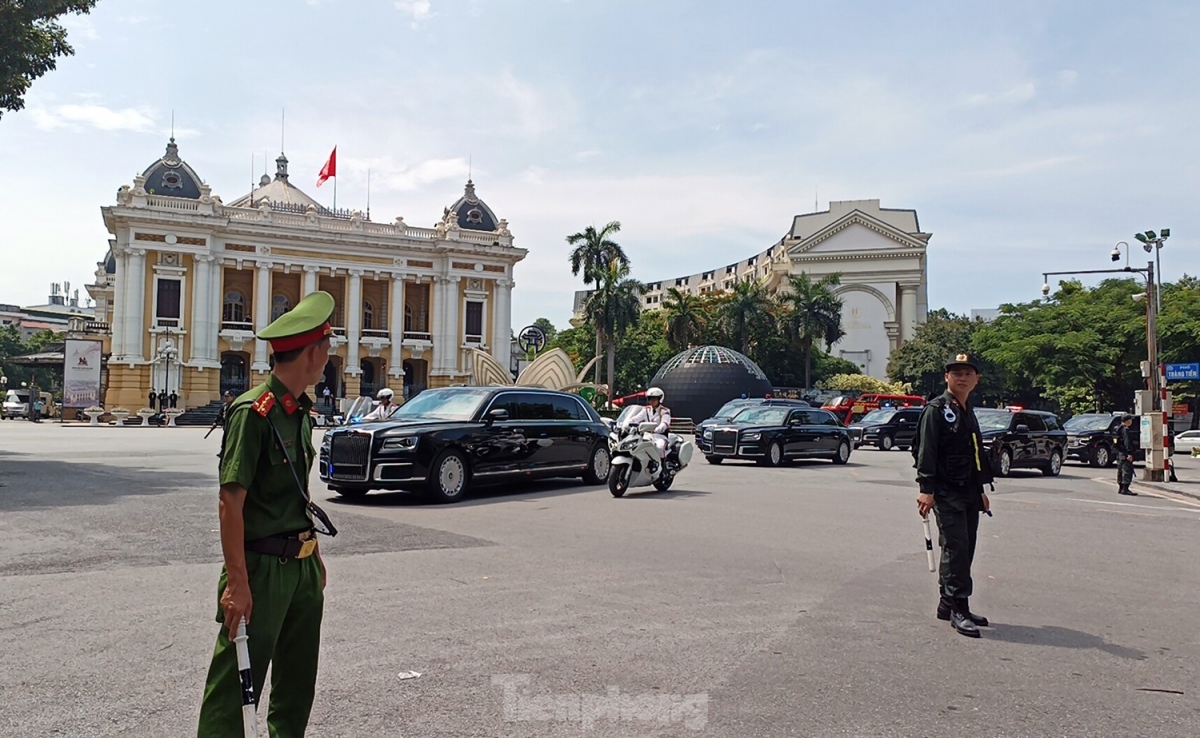 A convoy of cars and motorcycles arrives at the Hanoi Opera House.