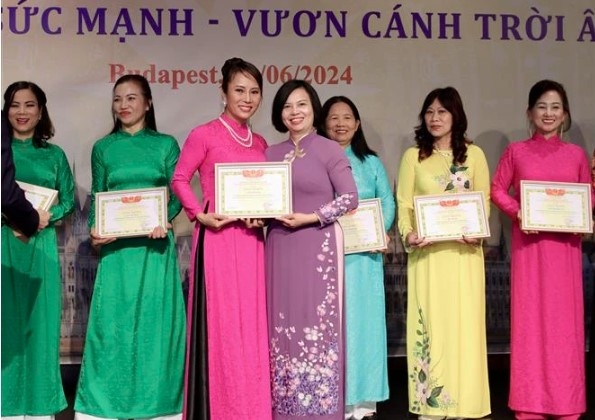 Ambassador Nguyen Thi Bich Thao presents certificates of merit to members of the Vietnamese women's union in Hungary for their contributions to its activities.