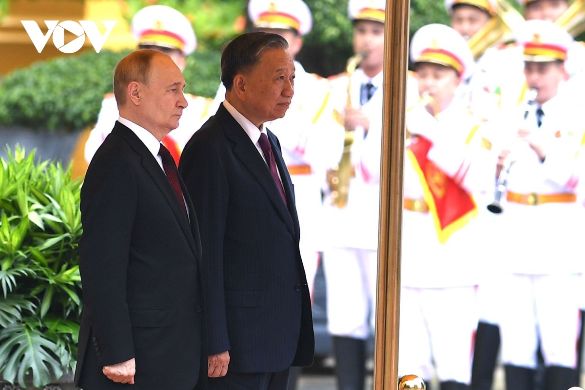 President To Lam invites his Russian counterpart Vladimir Putin to step on the podium while military bands play the national anthems of both nations.