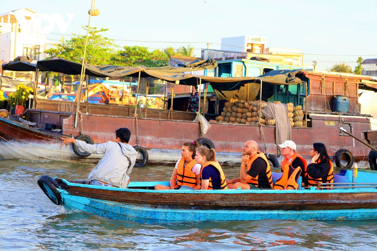 Foreign visitors on a tour of a floating market in southern Vietnam