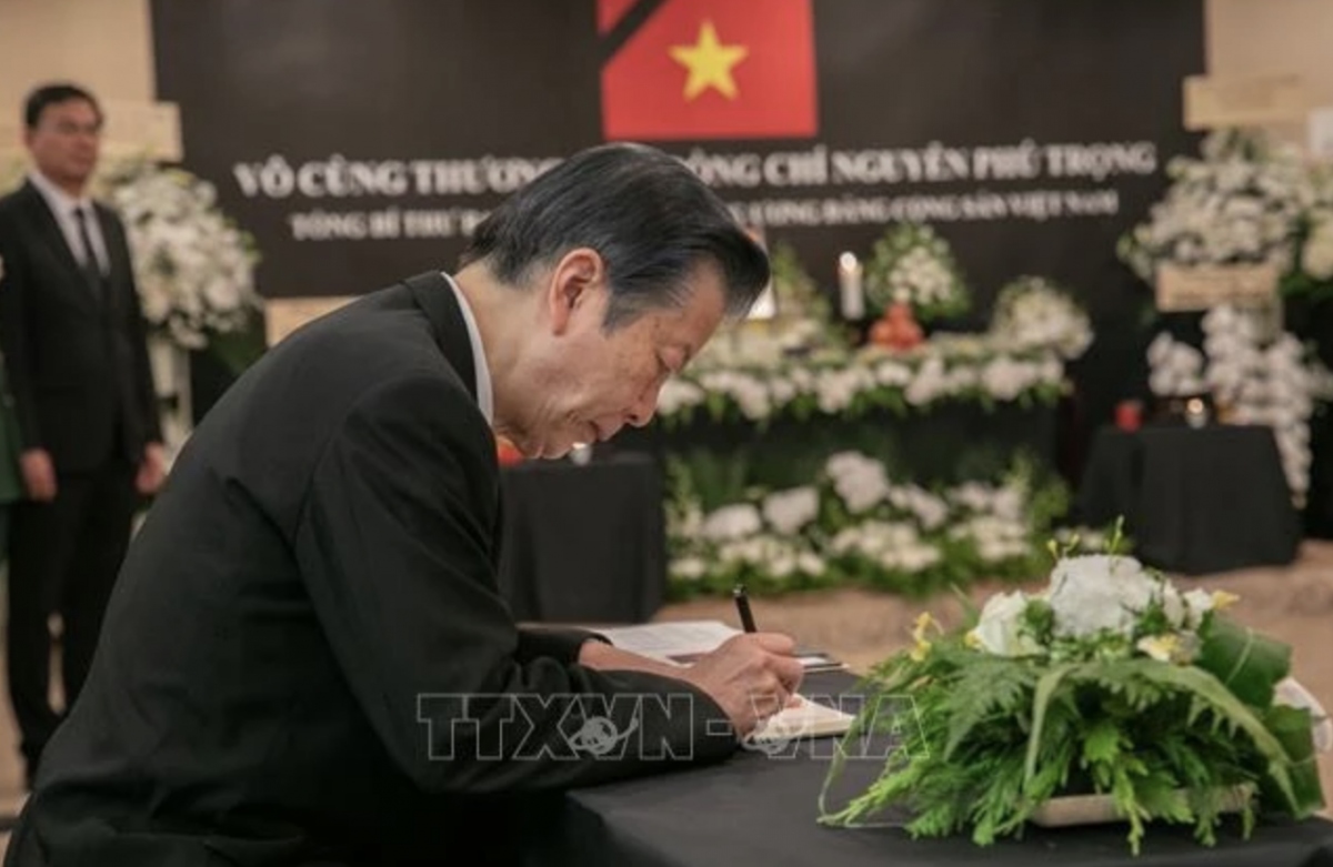 Japanese Senator Natsuo Yamaguchi writes in the condolence book. (Photo: VNA)