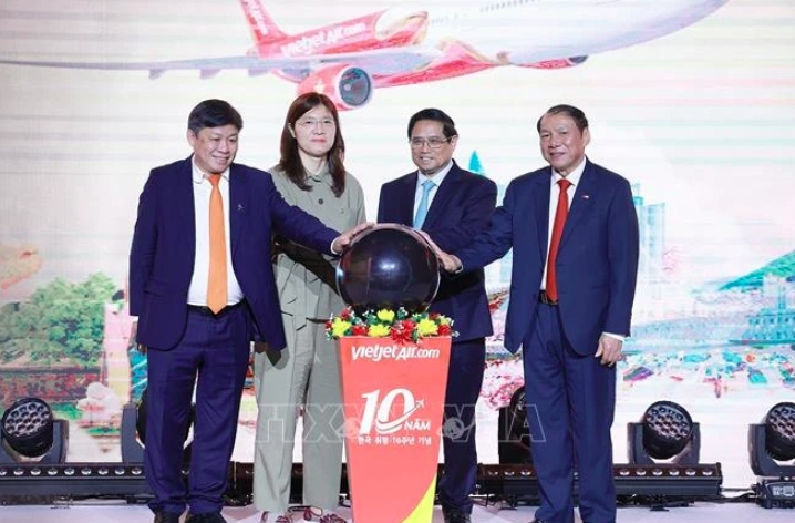 Prime Minister Pham Minh Chinh (2nd from right) and delegates join a symbolic ceremony to announce Vietjet's new Daegu - Nha Trang route in Seoul on July 1.
