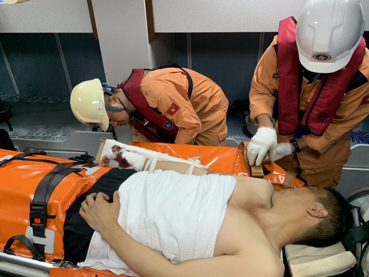 Members of the Vietnam Maritime Rescue Force give first aid to the Chinese seafarer and bring him back to shore for emergency treatment