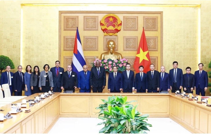 PM Pham Minh Chinh (8th from right), President of the National Assembly of People's Power of Cuba Esteban Lazo Hernandez (9th from right), and officials of the two countries pose for a group photo at the meeting in Hanoi on July 24.