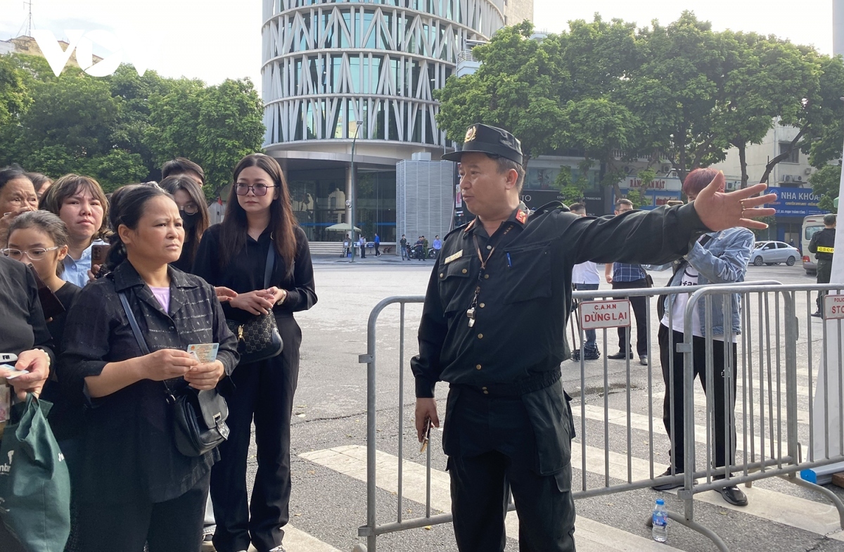 Mourners are guided to scan their ID cards by relevant forces.