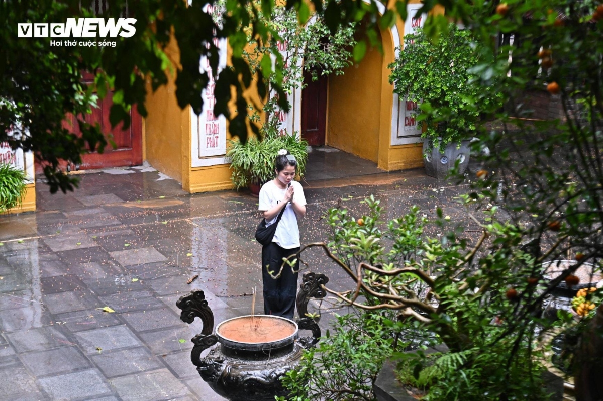 A young person offers incense at the pagoda, expressing gratitude to the nation’s beloved leader.