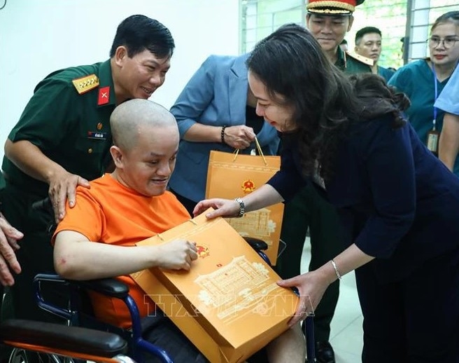 Vice President Vo Thi Anh Xuan gives a gift to an AO victims at the centre for caring, nurturing and treating victims of AO/dioxin in Ba Vi district, Hanoi.