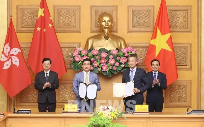 Deputy Prime Minister Tran Luu Quang (R) and Chief Executive of the Hong Kong Special Administrative Region (China) Lee Ka-chiu (L) witness the exchange of the MoU between Vietnam Airlines and the Hong Kong International Airport (HKIA).