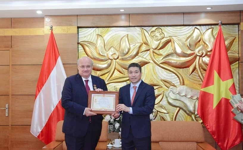 VUFO President Phan Anh Son (R) presents “For peace and friendship among nations” insignia to Austrian Ambassador to Vietnam Hans-Peter Glanzer