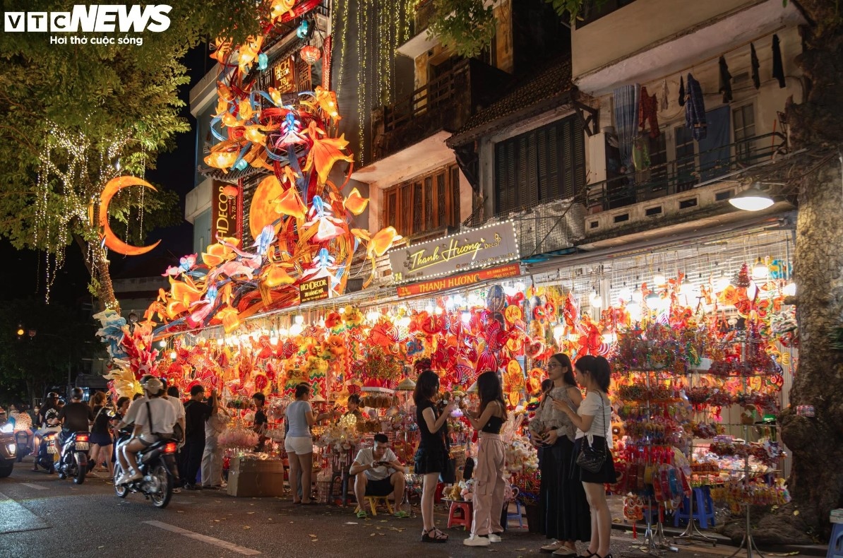 A shop is decorated with giant carp-shaped lanterns, drawing plenty of attention from passers-by.