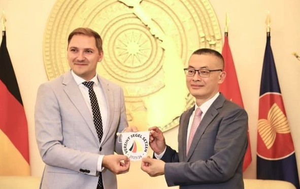 Parliamentary State Secretary of Mecklenburg-West Pomerania Patrick Dahlemann (L) presents a souvenir to Vietnamese Ambassador to Germany Vu Quang Minh