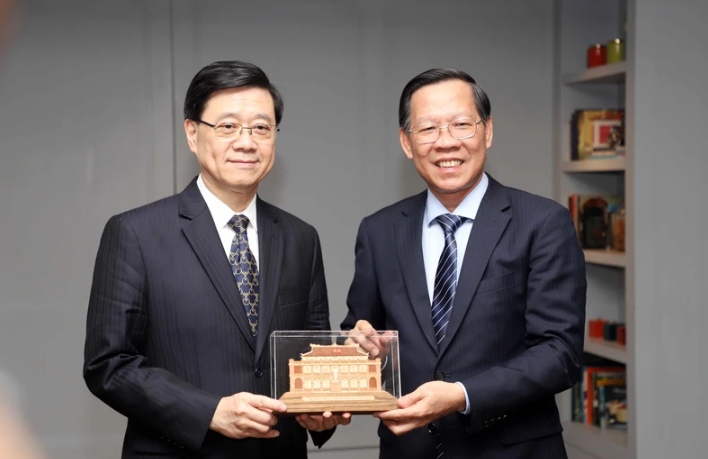 Chairman of the municipal People’s Committee Phan Van Mai (R) and Chief Executive of the Hong Kong Special Administrative Region John Lee Ka-chiu.