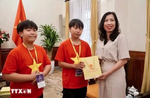 Deputy Minister of Foreign Affairs Le Thi Thu Hang (R) presents gifts to OV children from the RoK