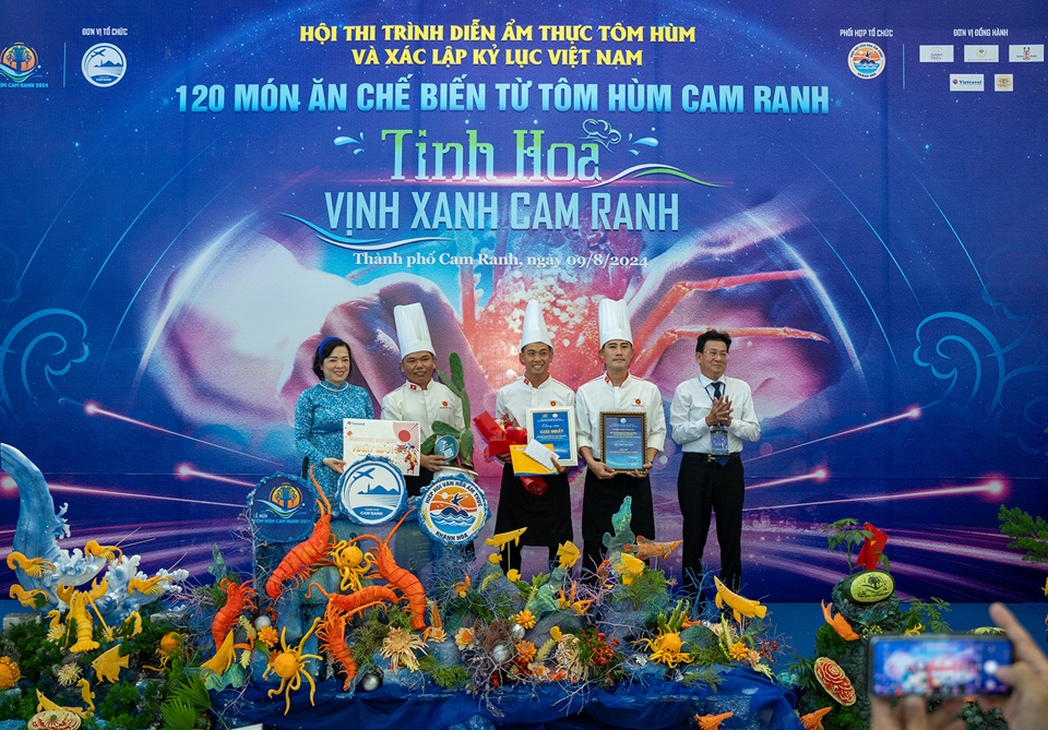 The organisers present the first prize to a team from Ninh Thuan province who have created six dishes made from Cam Ranh lobster.