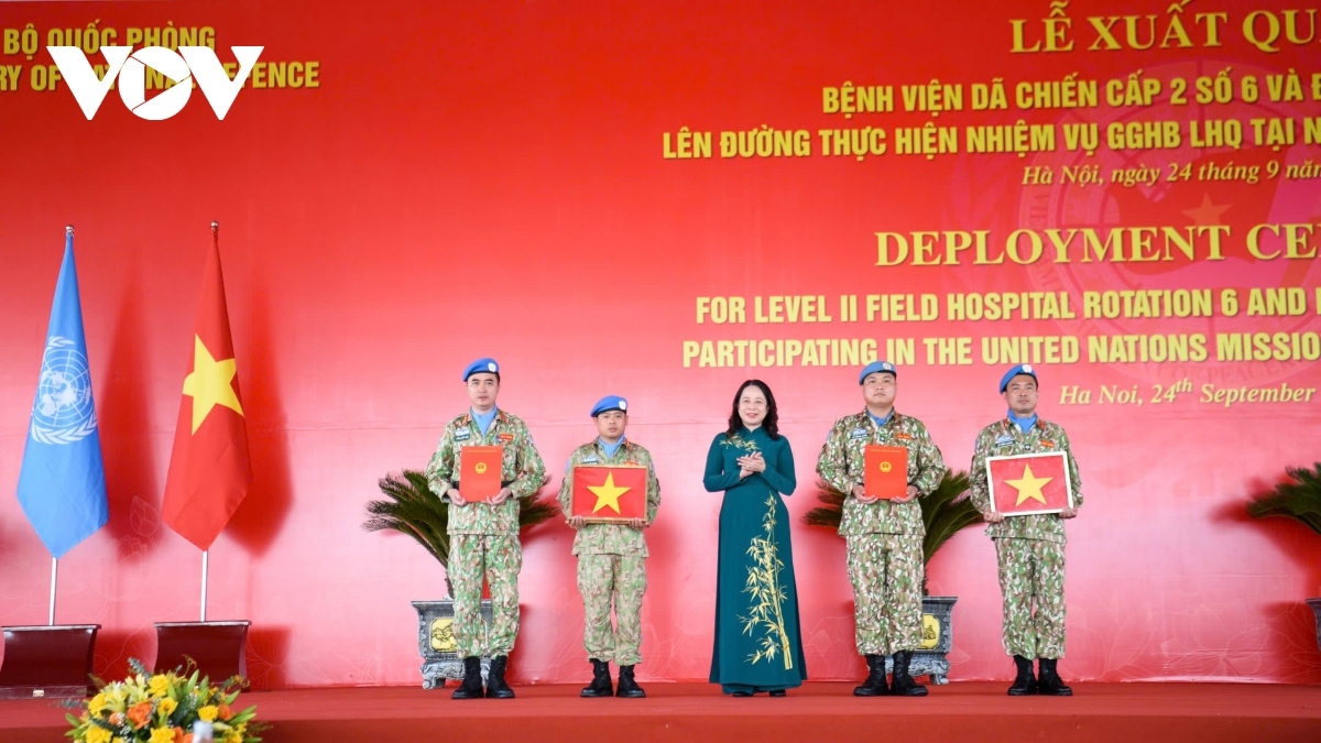Vice President Vo Thi Anh Xuan presents the national flag to Vietnamese peacekeepers.