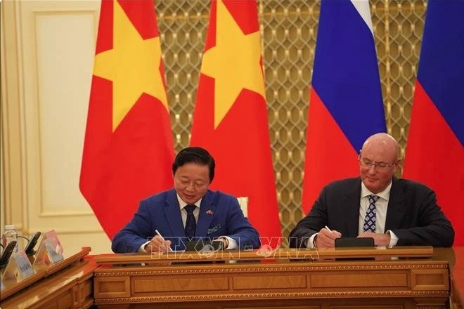 Deputy Prime Minister Tran Hong Ha (L) and his Russian counterpart Dmitry Chernyshenko sign the meeting's minute