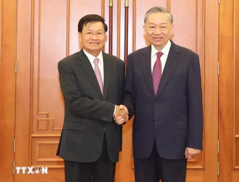 General Secretary of the Communist Party of Vietnam (CPV) Central Committee and State President To Lam (R) shake hands with General Secretary of the Lao People’s Revolutionary Party (LPRP) Central Committee and President of Laos Thongloun Sisoulith