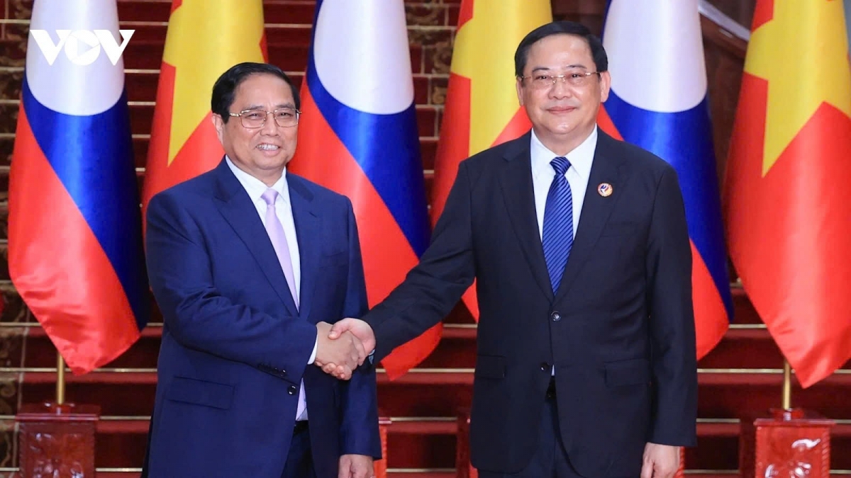 Vietnamese Prime Minister Pham Minh Chinh (L) and his Lao counterpart Sonexay Siphandone shaking hands ahead of their meeting in Vientiane on October 8.