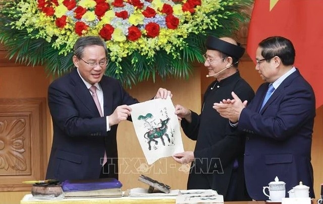 Vietnamese Prime Minister Pham Minh Chinh (R) and Chinese Premier Li Qiang got hands-on experience of making a Dong Ho folk painting. (Photo: VNA)