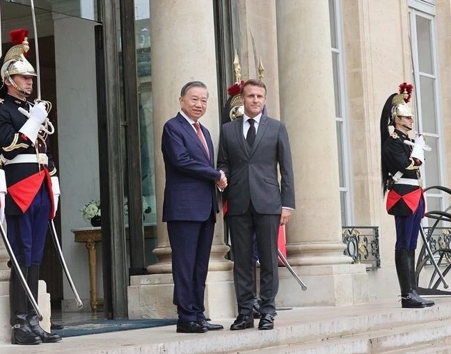 French President Emmanuel Macron (R) welcomes Vietnamese Party General Secretary and State President To Lam (Photo: VNA)