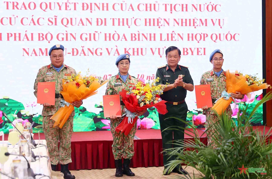 Senior Lieutenant General Hoang Xuan Chien presents the Decision of the President to the three officers. (Photo: PANO)