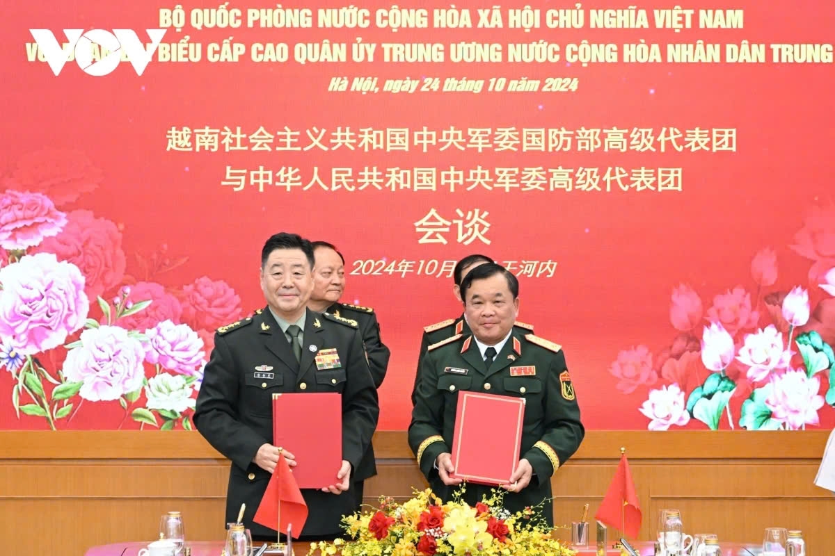 Representatives from the Ministry of National Defense of Vietnam and the Ministry of National Defense of China sign the cooperation document sin Hanoi on October 24