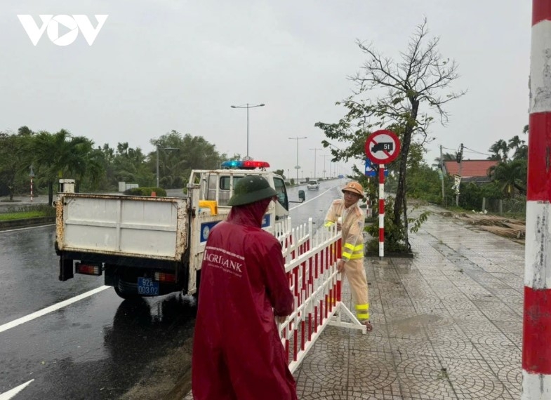 Policemen set up barriers to ban vehicles from crossing Cua Dai bridge, Hoi An city in order to ensure traffic safety amidst the severe weather conditions.