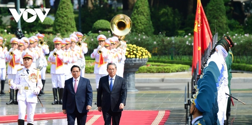 PM Pham Minh Chinh and Chinese Premier Li Qiang review the guard of honour of the People's Army of Vietnam. 