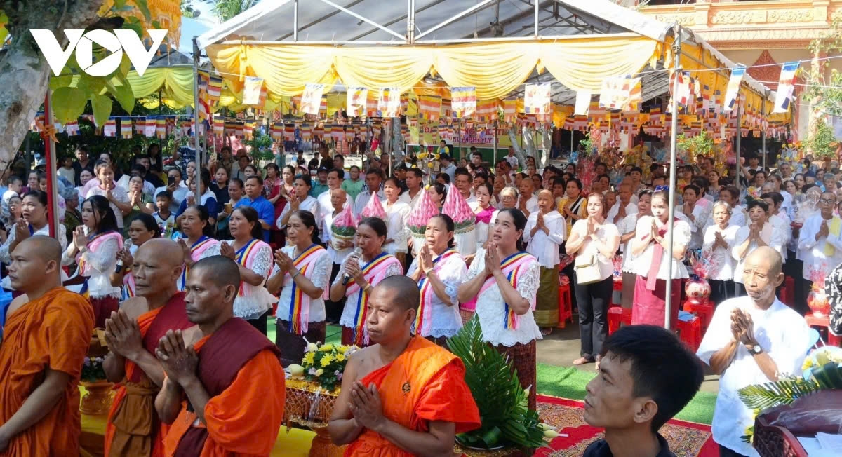 The monks and Buddhist followers perform the flag-raising ceremony.