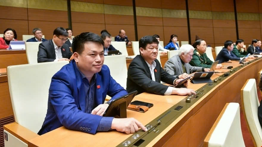 National Assembly deputies press the button to pass a draft law at the eighth legislative session in Hanoi