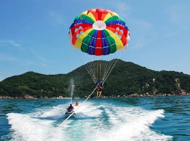 Paragliding is one of the most exciting adventure sports at sea as players are fitted with parachutes, then pulled up into the air. The expenditure for each game is VND500,000 to VND600,000 per 10 minutes, depending on the number of players. (Photo: vtcnews.vn)