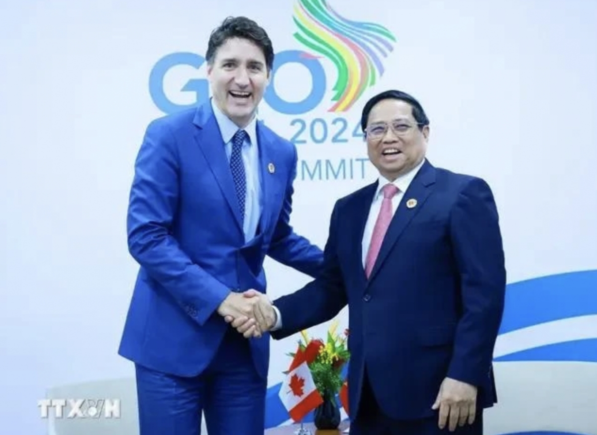 PM Pham Minh Chinh (R) shakes hands with his Canadian counterpart Justin Trudeau (Photo: VNA)