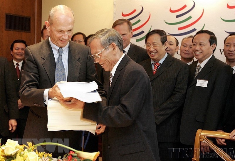 On November 7, 2006, Vietnamese Minister of Trade Truong Dinh Tuyen and WTO Director-General Pascal Lamy exchange documents on Vietnam's accession to the WTO, at the WTO headquarters in Geneva, Switzerland. (Photo: VNA)