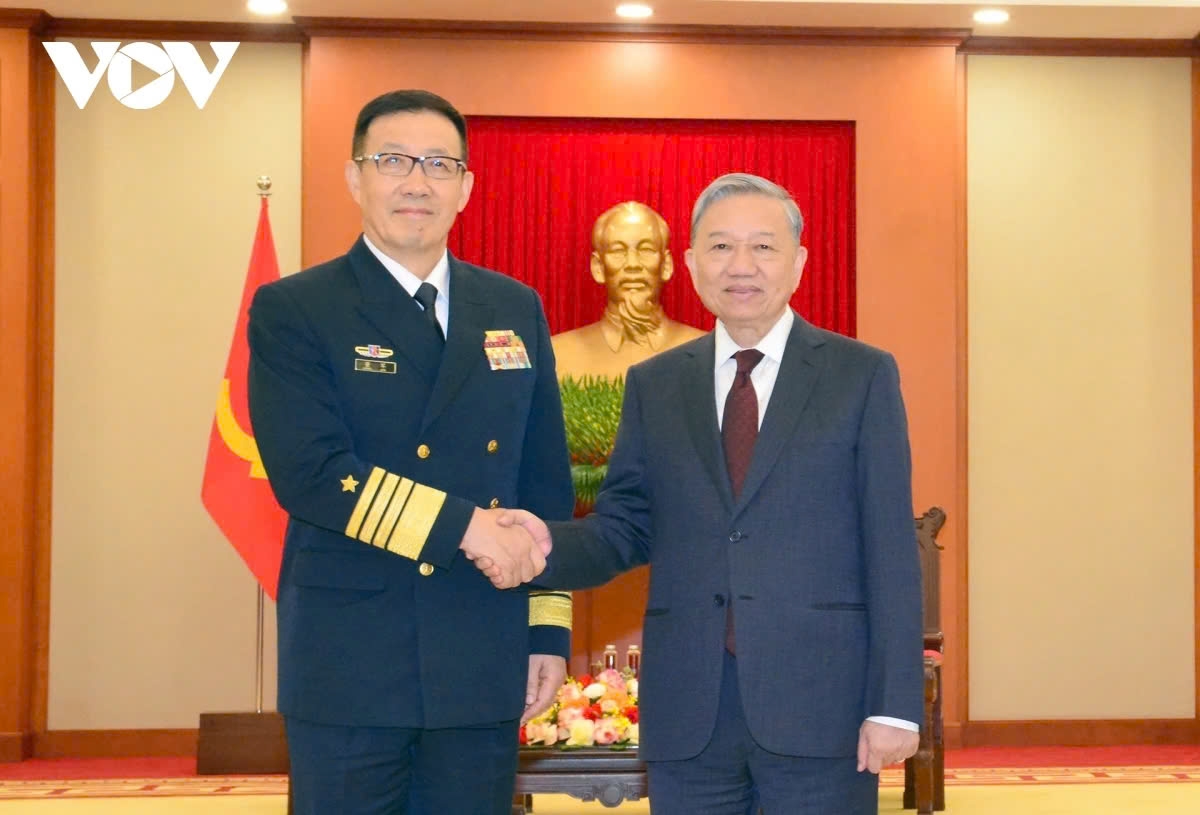 Party General Secretary To Lam (R) shaking hands with Chinese Defense Minister Admiral Dong Jun ahead of their meeting in Hanoi on December 19