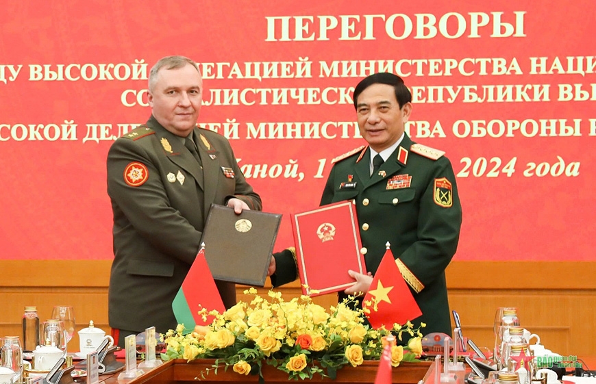 General Phan Van Giang, Minister of National Defense of Vietnam, and Lieutenant General Viktor Gennadievich Khrenin, Minister of Defense of Belarus, sign and exchange a number of documents on defense cooperation. (Photo: PANO) 