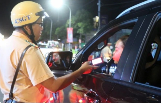 A police officer in Long Xuyen city, An Giang province, check alcohol levels of a driver.
