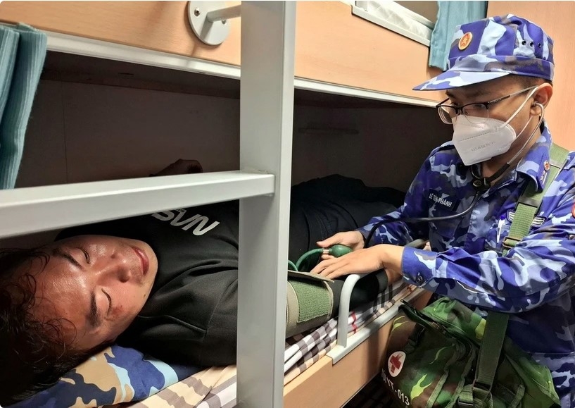A distressed Chinese sailor receives medical assistance (Photo: VNA)