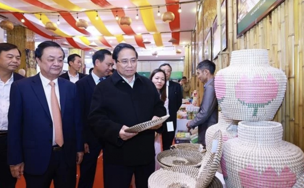 Prime Minister Pham Minh Chinh visits a booth displaying handicraft and fine arts products. (Photo: VNA)