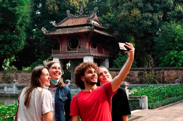 Foreign tourists pose for a group photo at a tourist destination in Vietnam 