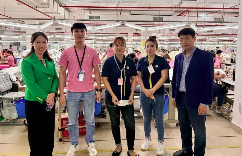 Le Ngoc Toan, First Secretary and Head of the Labour Management and Expert Committee in Malaysia (first, right) and First Secretary Thai Thi Huong (first, left) take a photo with Vietnamese workers at Ramatex Textiles factory in Johor.