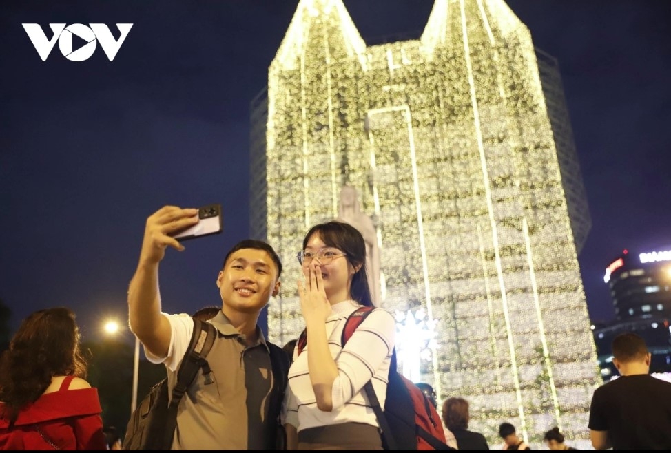 Young people in the southern city snap photos under the sparkling lights in front of the church.