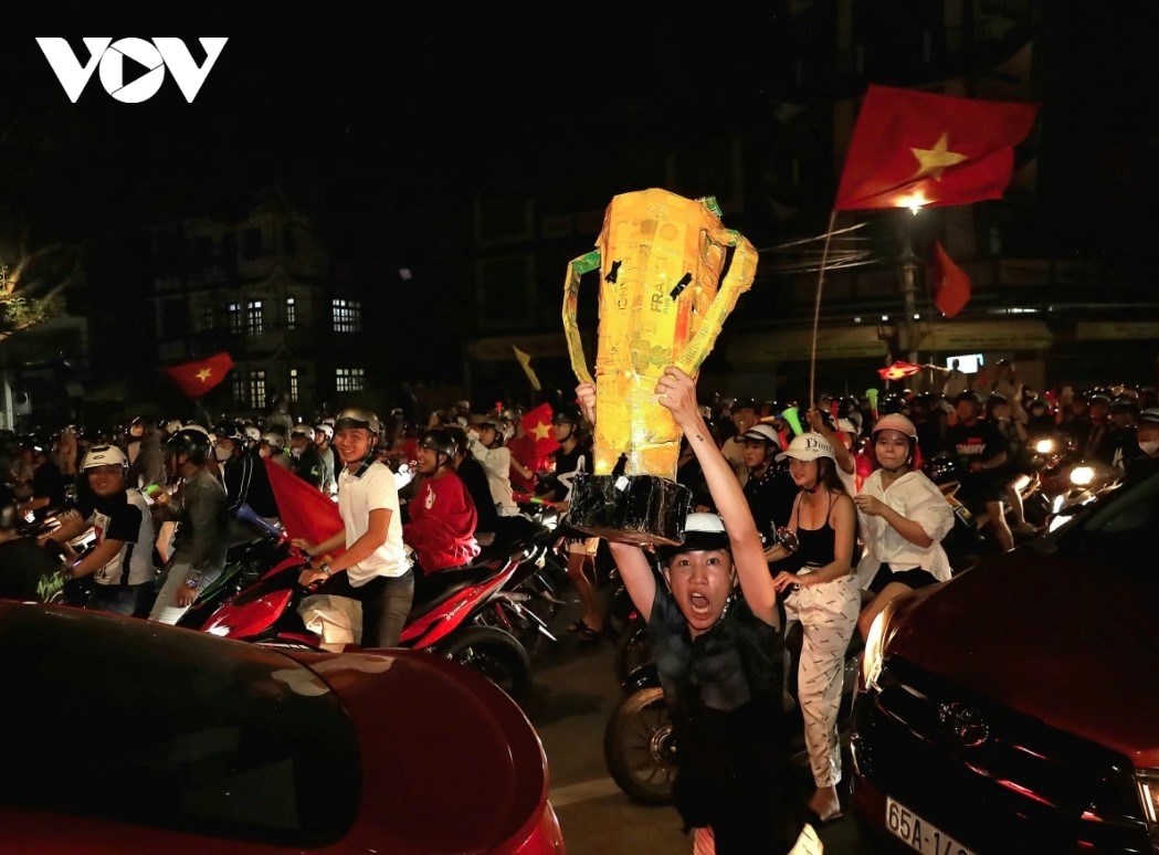 After the referee blew the final whistle to end the match, thousands of football fans in Can Tho flood the streets carrying flags and trophies for celebration.